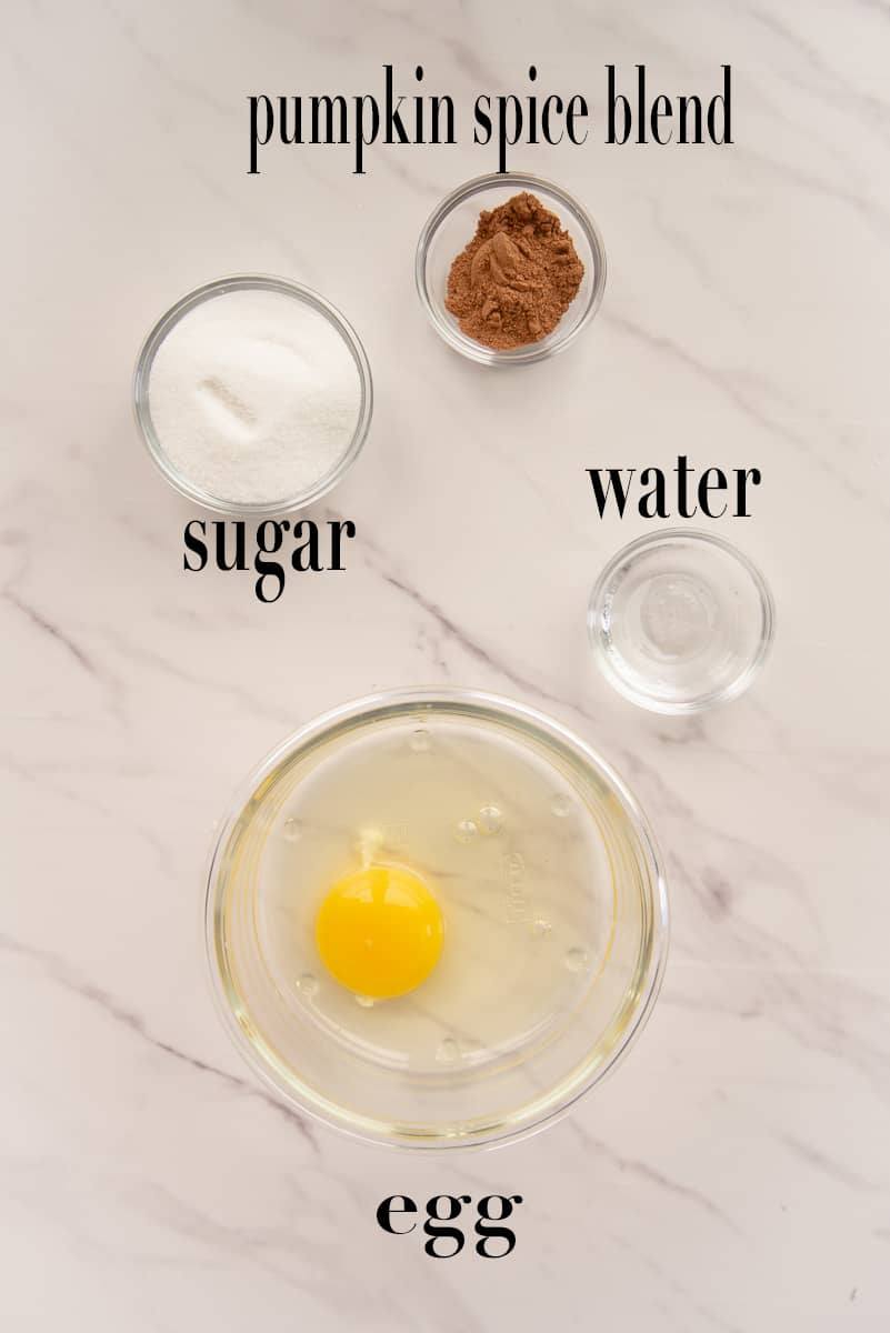 The ingredients to make the egg wash and the spiced sugar are labeled and on a white countertop.