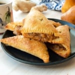 A pile of Ginger Pear Turnovers on a dark blue plate.