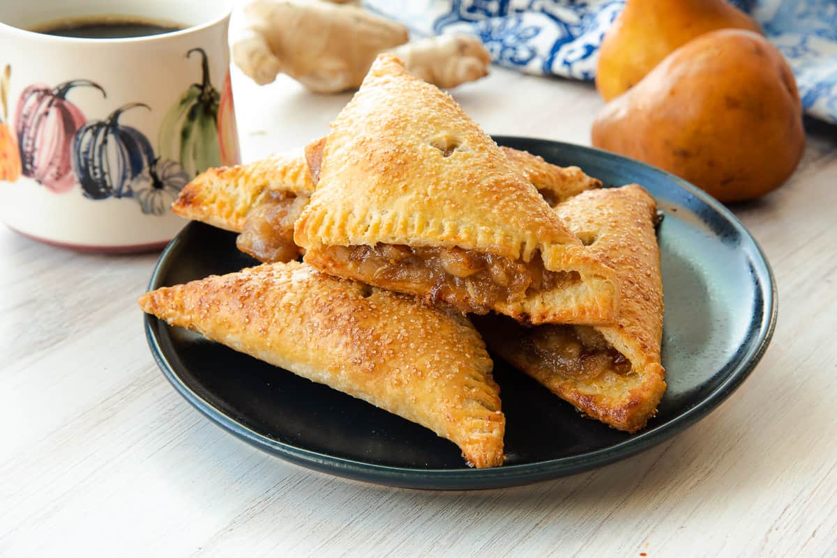 A pile of Ginger Pear Turnovers on a dark blue plate.