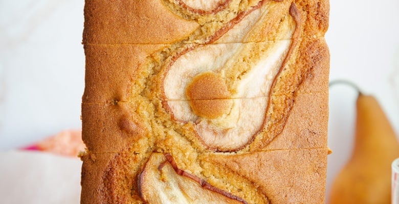 A standing loaf of Pear Cardamom Bread reveals sliced pears on the surface.