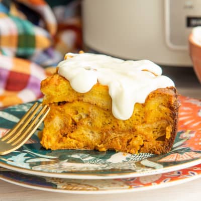 A serving of Slow Cooker Pumpkin French Toast covered in cream cheese glaze.