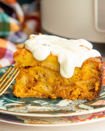 A serving of Slow Cooker Pumpkin French Toast covered in cream cheese glaze.