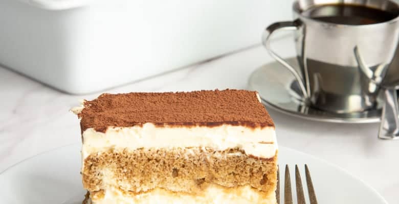 Classic Tiramisu from Scratch on a white plate next to a fork.
