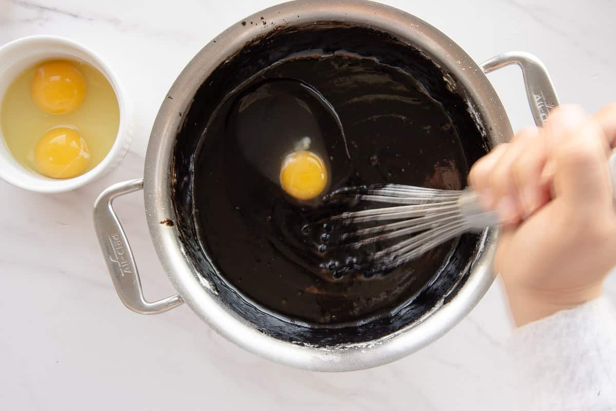 Eggs are beaten into the batter with a whisk.