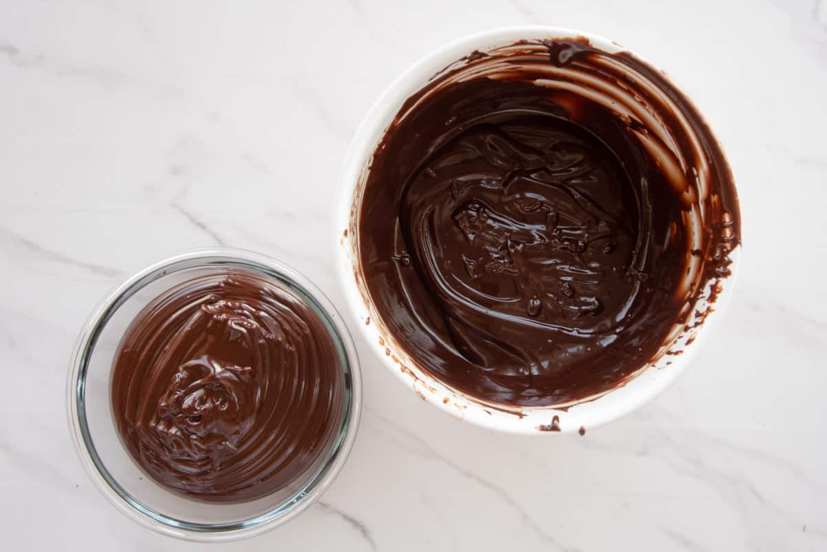 The chocolate ganache is separated into two different bowls after being mixed.