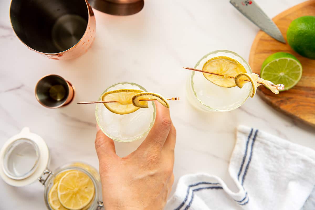 A hand grabs a highball glass with a Gin Rickey Cocktail in it.