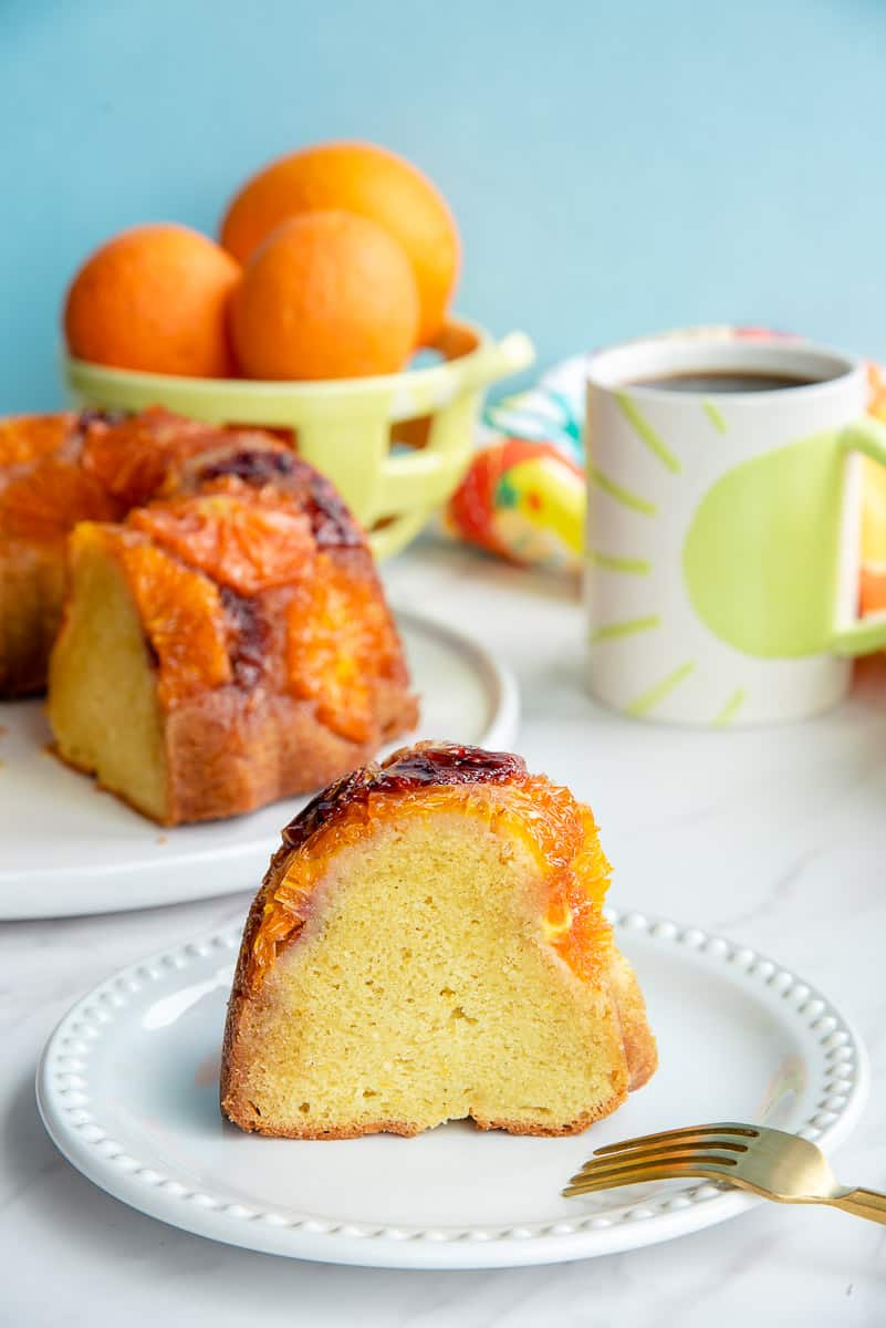 A slice of Orange Ginger Coffee Cake on a white plate with a beaded rim.
