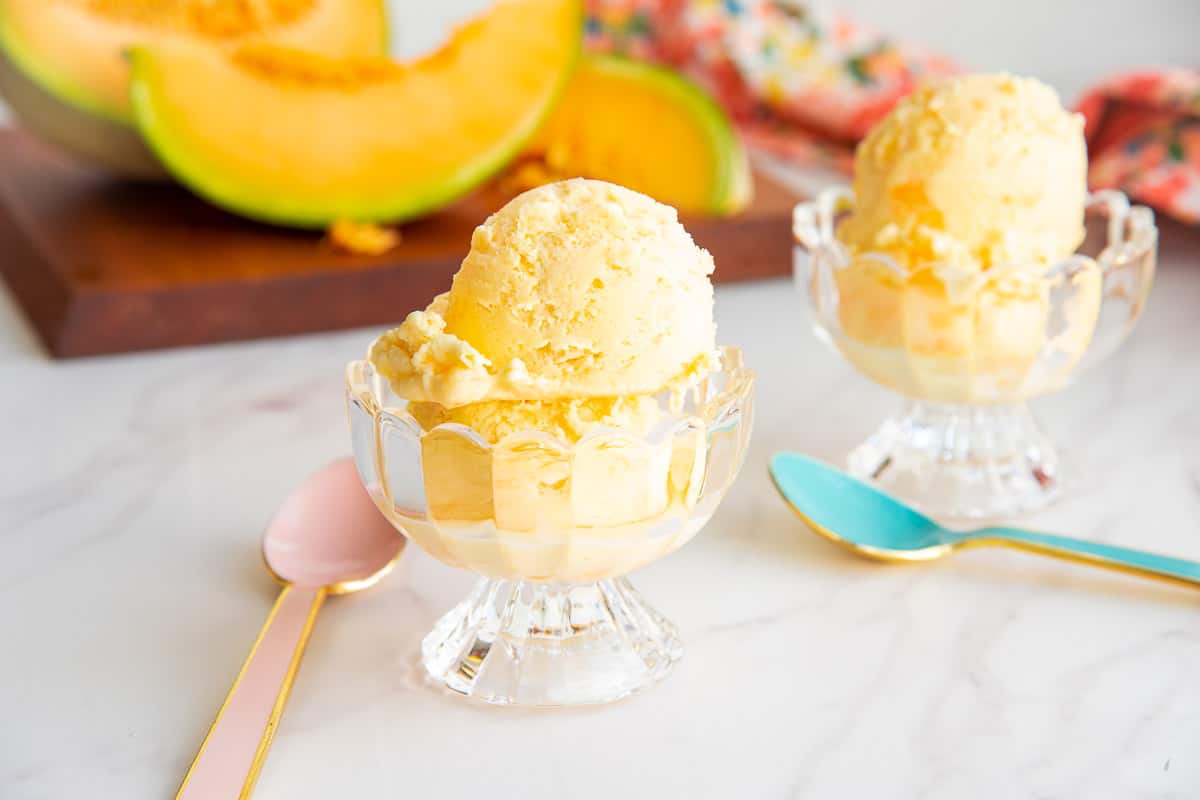 Scoops of cantaloupe frozen custard in clear glass dessert cups.