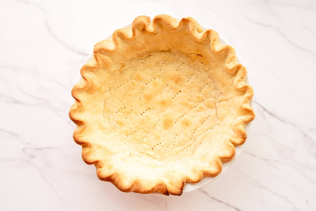 The baked pie shell on a white countertop.