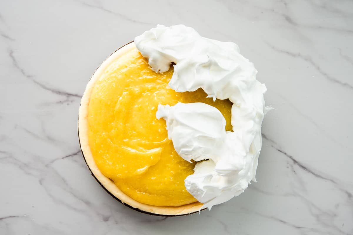 The lemon meringue topping is spread on top of the baked cheesecake.