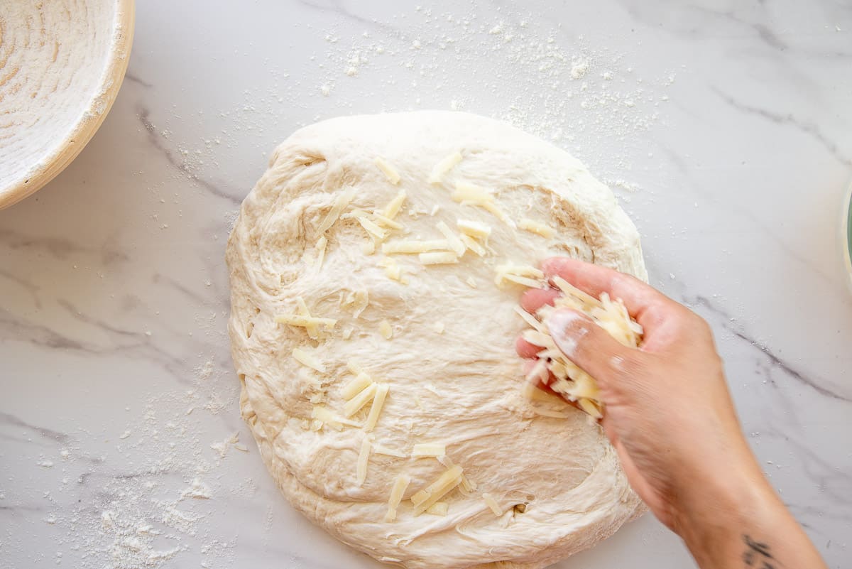 Shredded cheese is sprinkled on the dough.