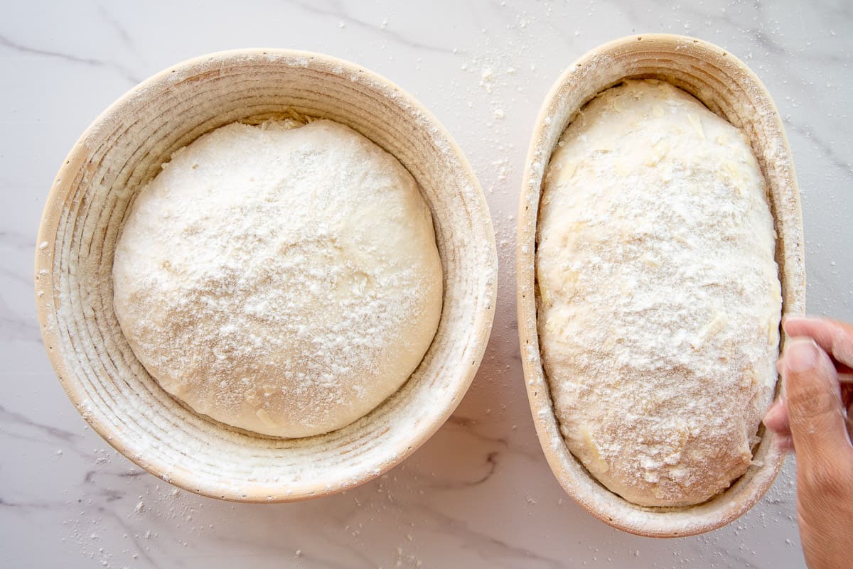The raw dough in their bannetons are dusted with flour before being transferred to their sheet pan to bake.