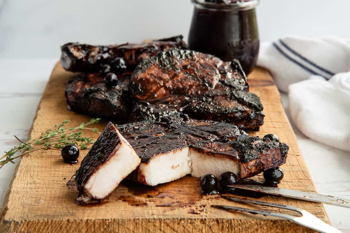 A Grilled Thick-Cut Pork Chop is cut open to reveal a juicy interior.
