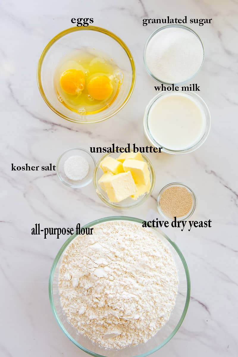 The ingredients needed to make the sweet roll dough are labeled on a white countertop.