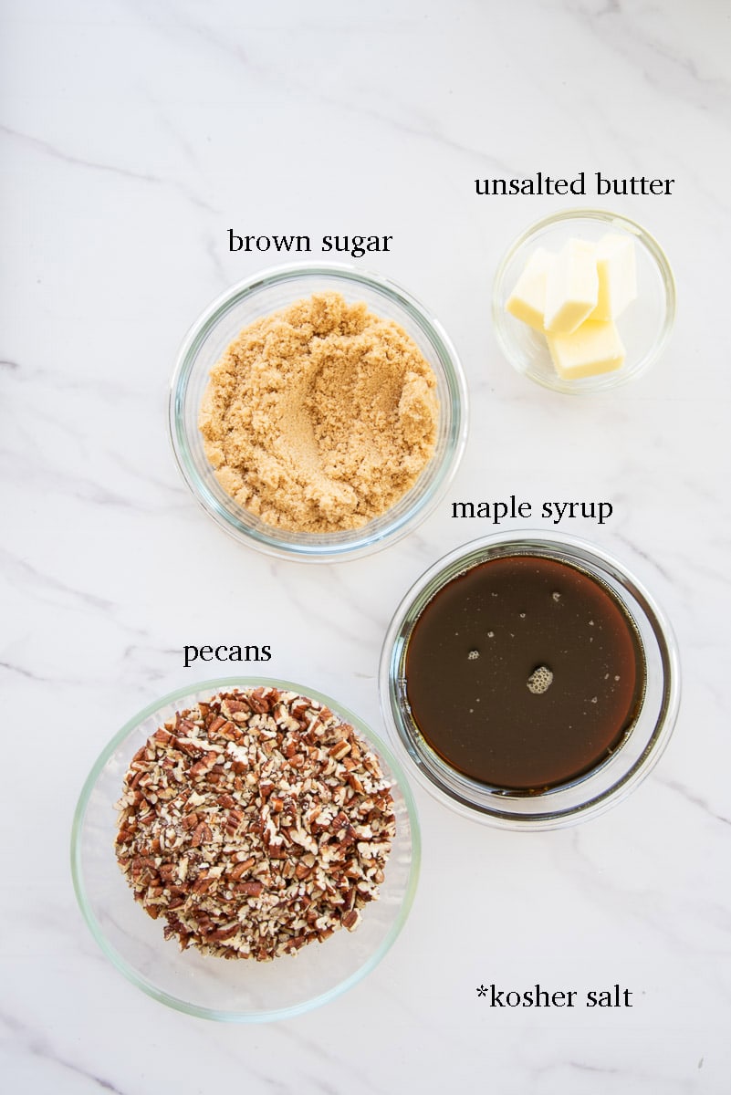 The ingredients needed to make the pecan and maple caramel sauce are labeled on a white countertop.