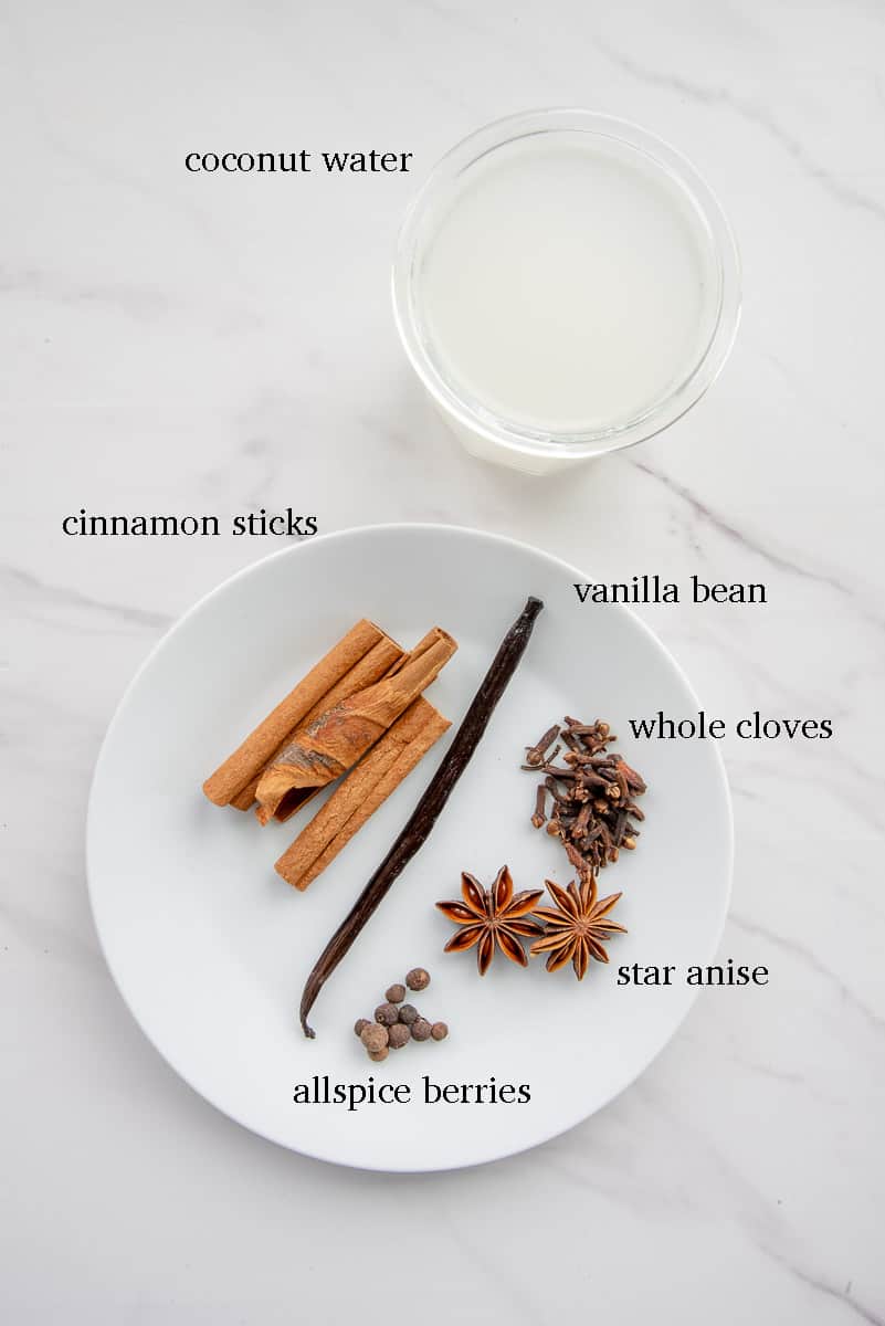 Ingredients to make the spice tea labeled in black and on a white countertop.