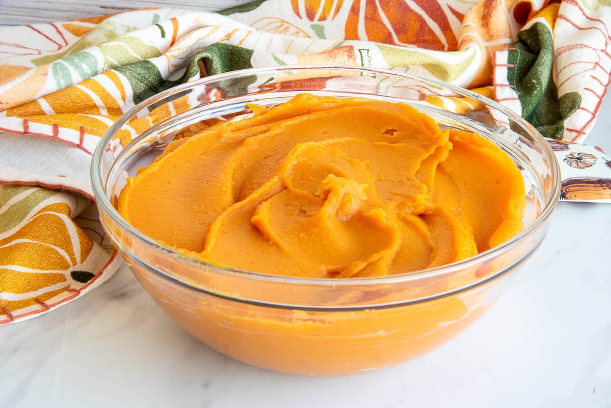 Sweet potato puree in a clear glass mixing bowl.