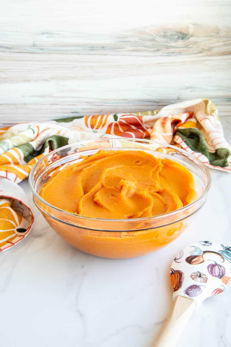 A clear glass mixing bowl filled with sweet potato puree.