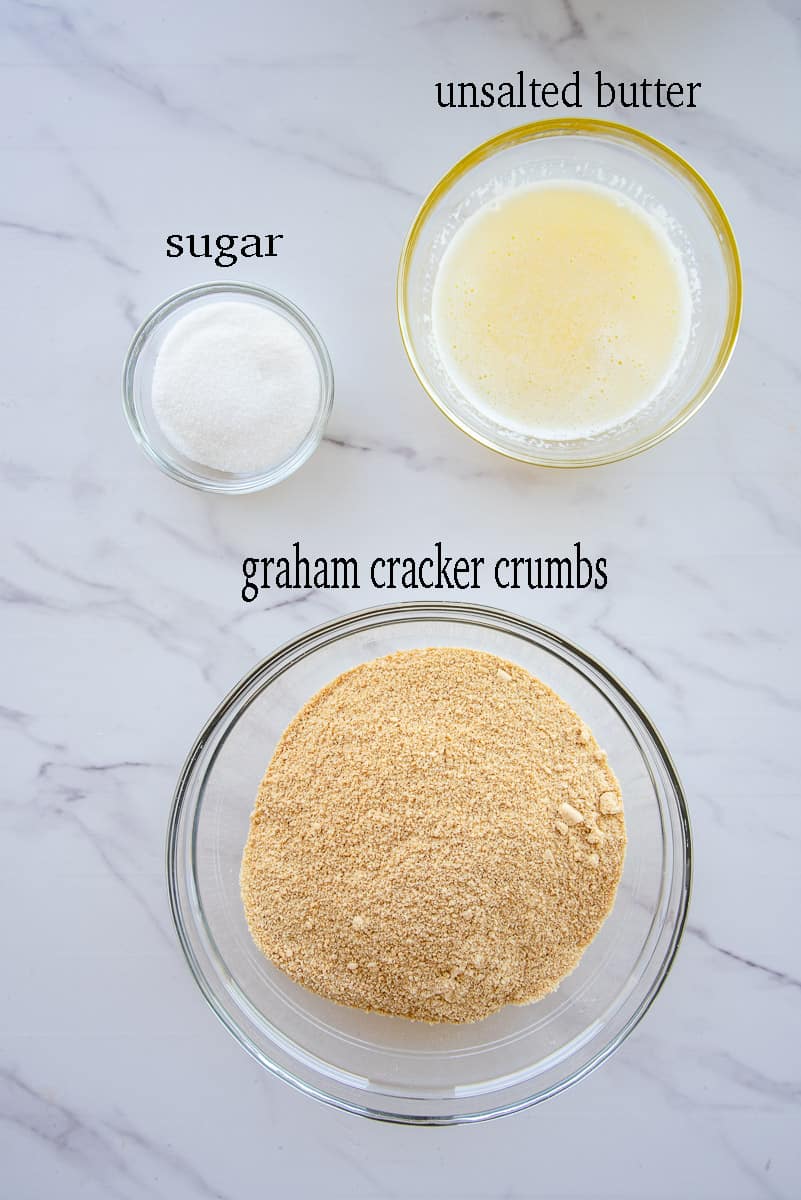 The ingredients to make the graham cracker crust are labeled on a white countertop.