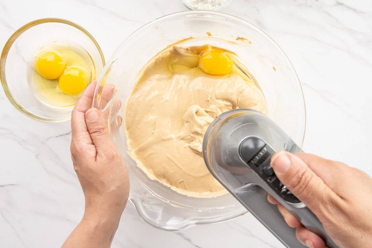 Eggs are added to the batter with a hand mixer.