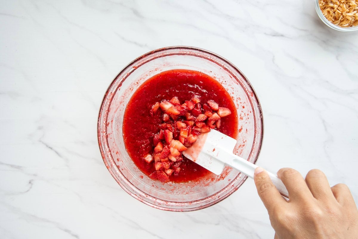 The reserved fruit is folded into the thickened puree with a rubber spatula.