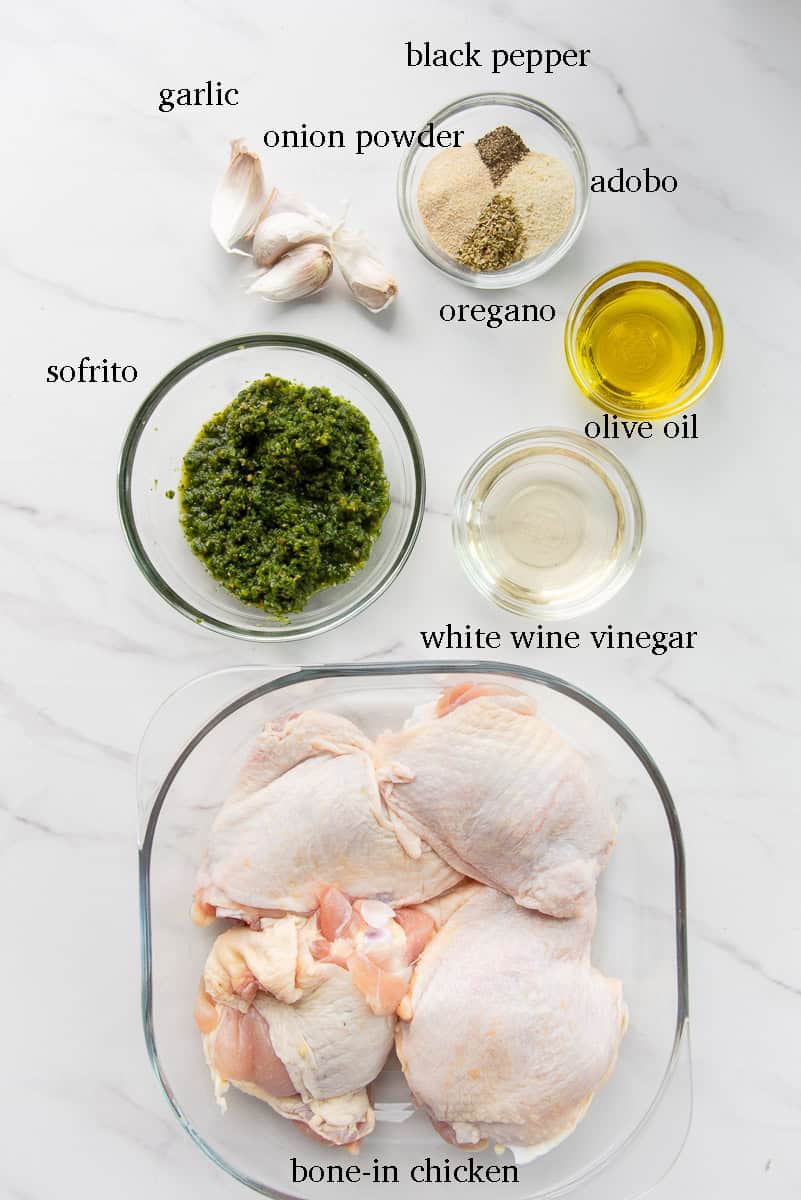 The ingredients needed to marinate the chicken for the recipe are on a white countertop and labeled.