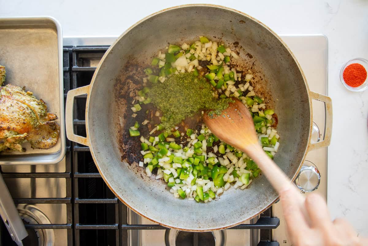 The aromatics and sofrito are added to the caldero to sauté.