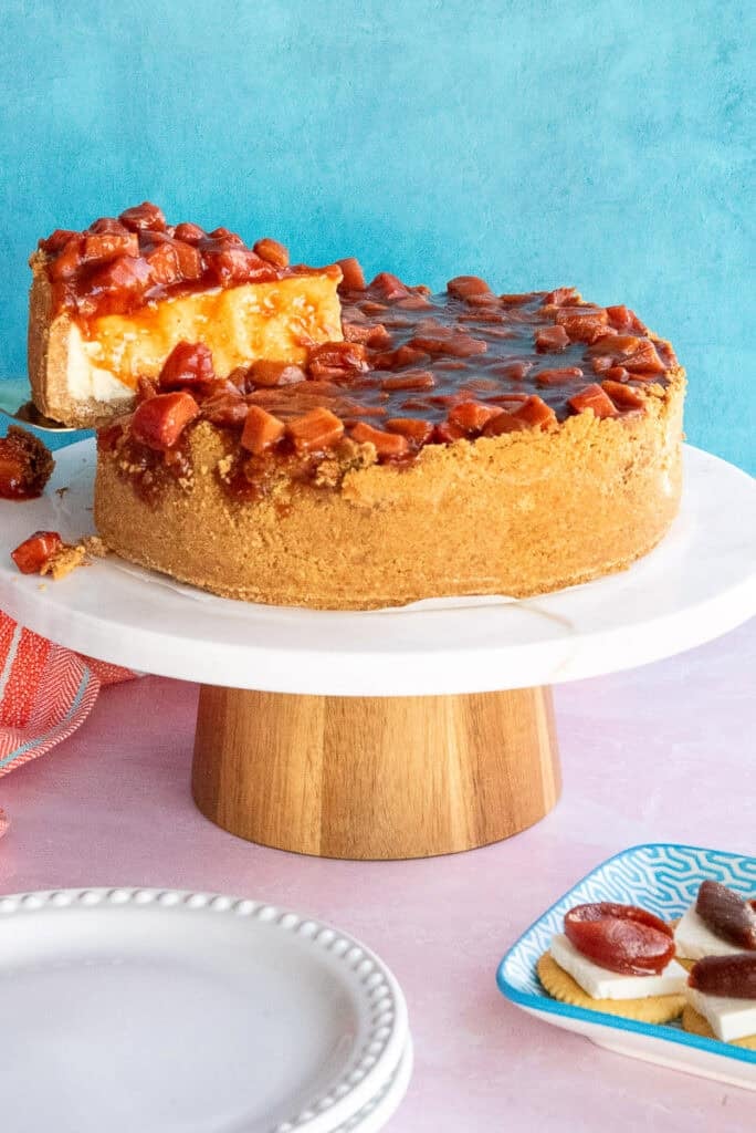 A slice is lifted from a whole Cascos de Guayaba Cheesecake.