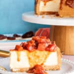 A Cascos de Guayaba Cheesecake slice on a white plate with the guava topping running down its side.