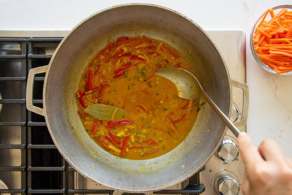 The herbs are added to the vegetable stock as it simmers in a caldero.