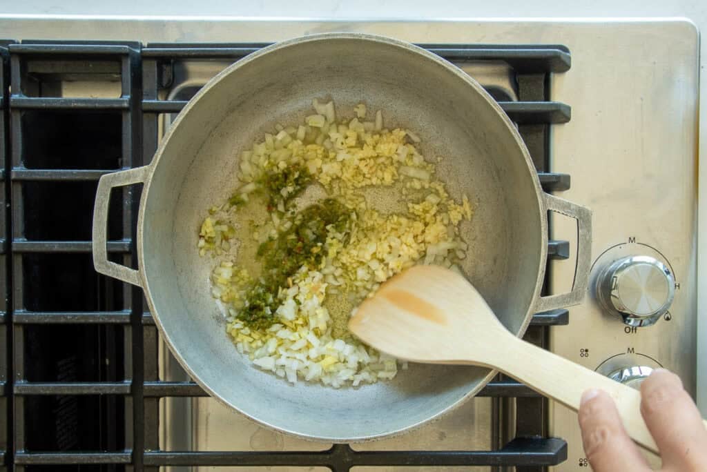 Aromatics are added to hot olive oil in a caldero.