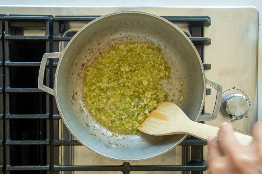 The aromatics are sautéed in the olive oil in a caldero.