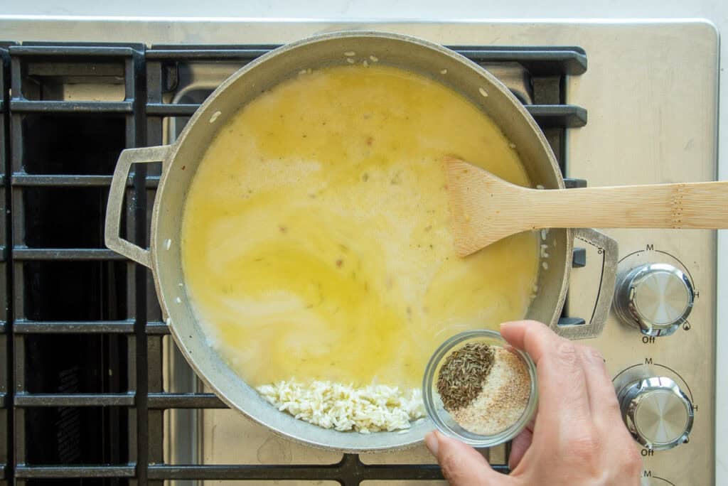 The thyme and spices are added to the pot with the coconut milk and vegetable stock.