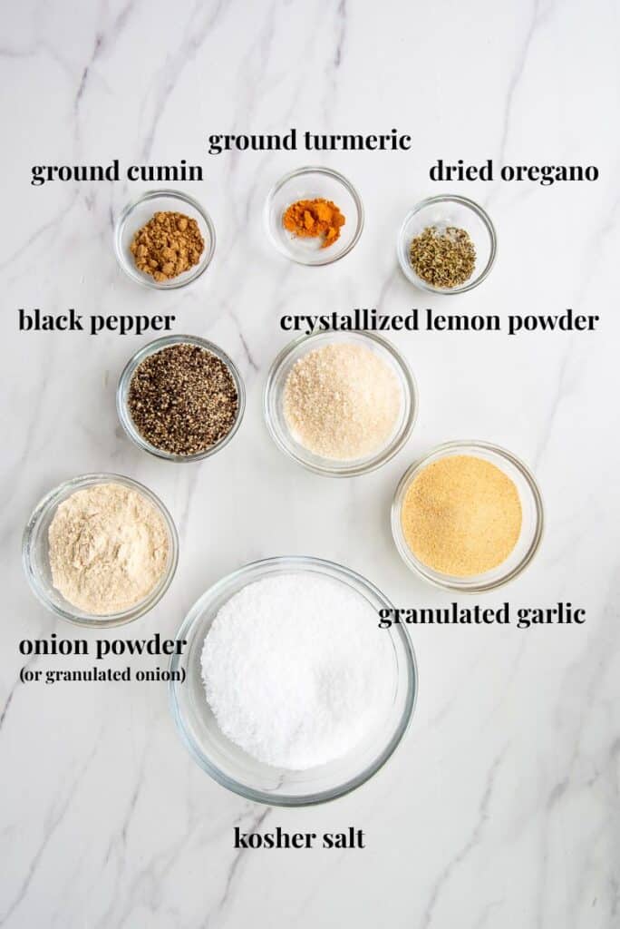 The ingredients needed to make Lemon Pepper Adobo Seasoning on a white countertop labeled with black text.