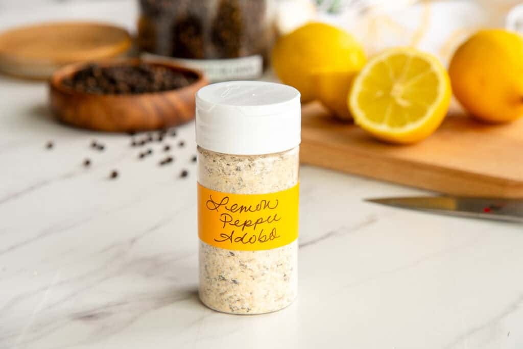 A plastic spice jar filled with the adobo seasoning blend.