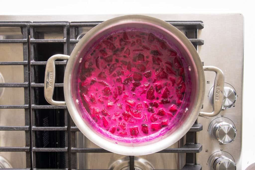 The simmering fruit produces a bright fuchsia syrup as it simmers on the stove.